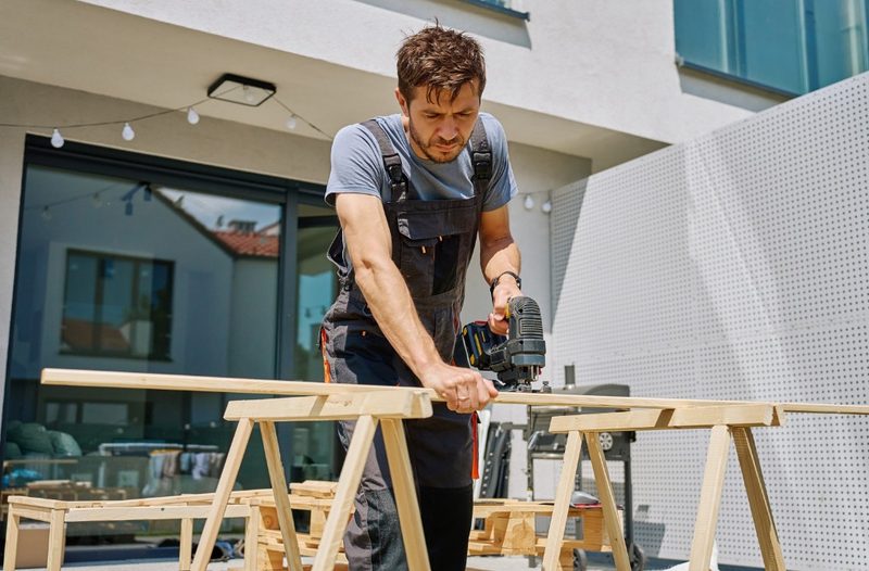 Carpintero cortando madera para una estructura exterior