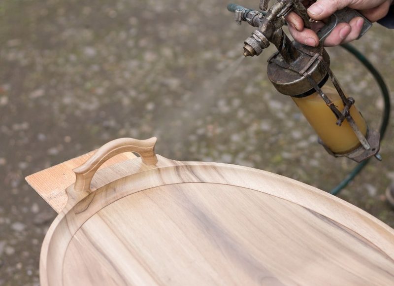 Lacado a pistola de una pieza de madera en el taller